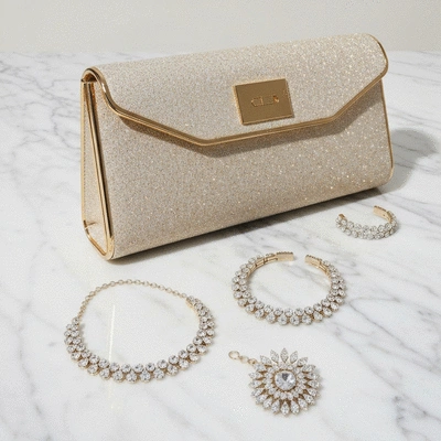 A collection of elegant cocktail accessories including statement jewelry and a chic clutch bag